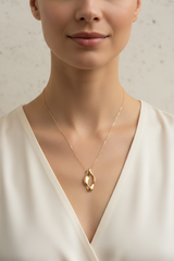 Elegant female model wearing Le Lumière feminine gold pendant necklace